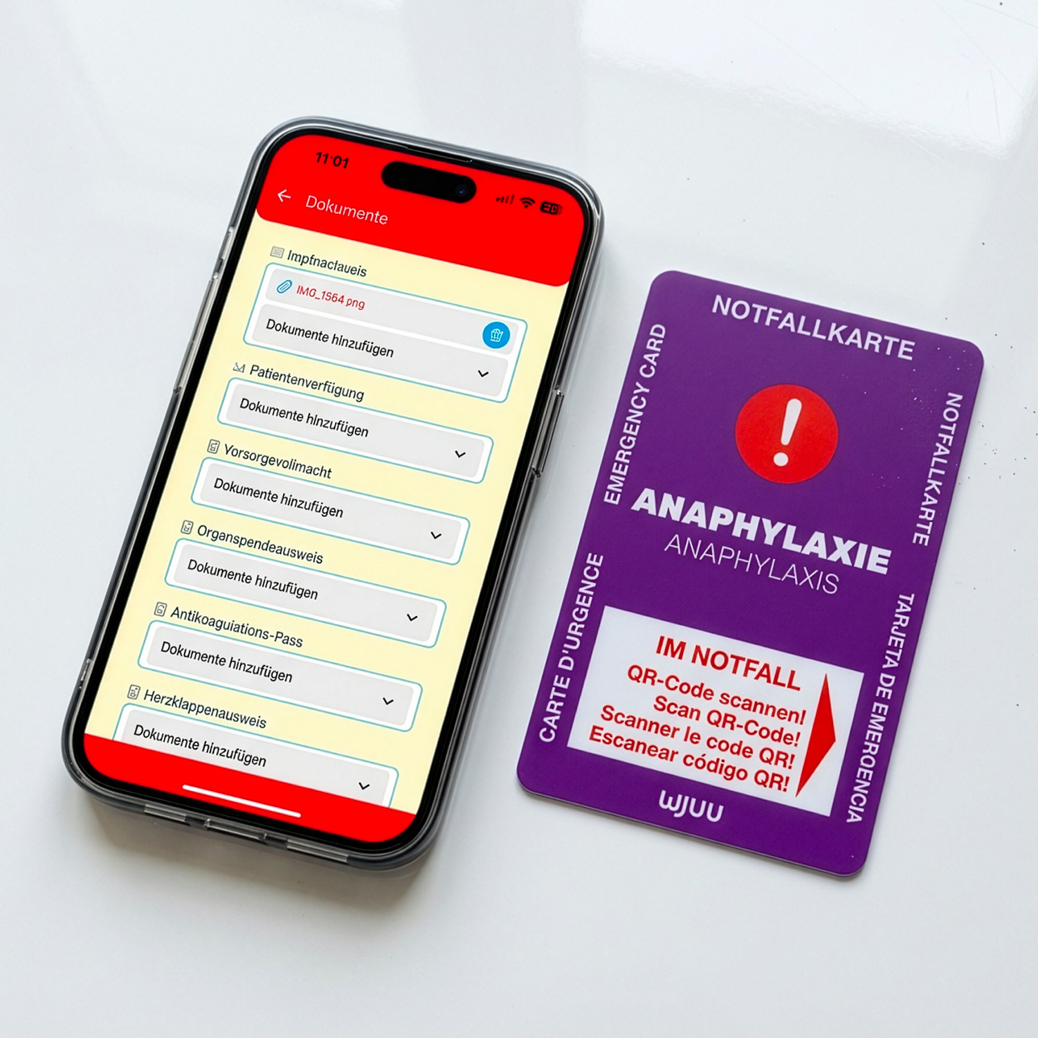 Wjuu Notfallkarte für Allergiker neben Smartphone mit digitalem Profil und Dokumenten