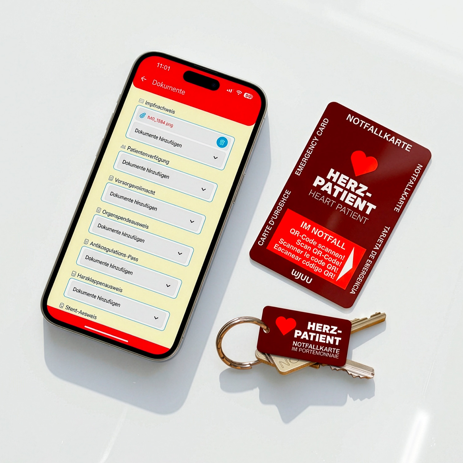 Wjuu Notfallkarte für Herzpatienten und SOS-Schlüsselanhänger neben Smartphone mit digitalem Profil und Dokumenten