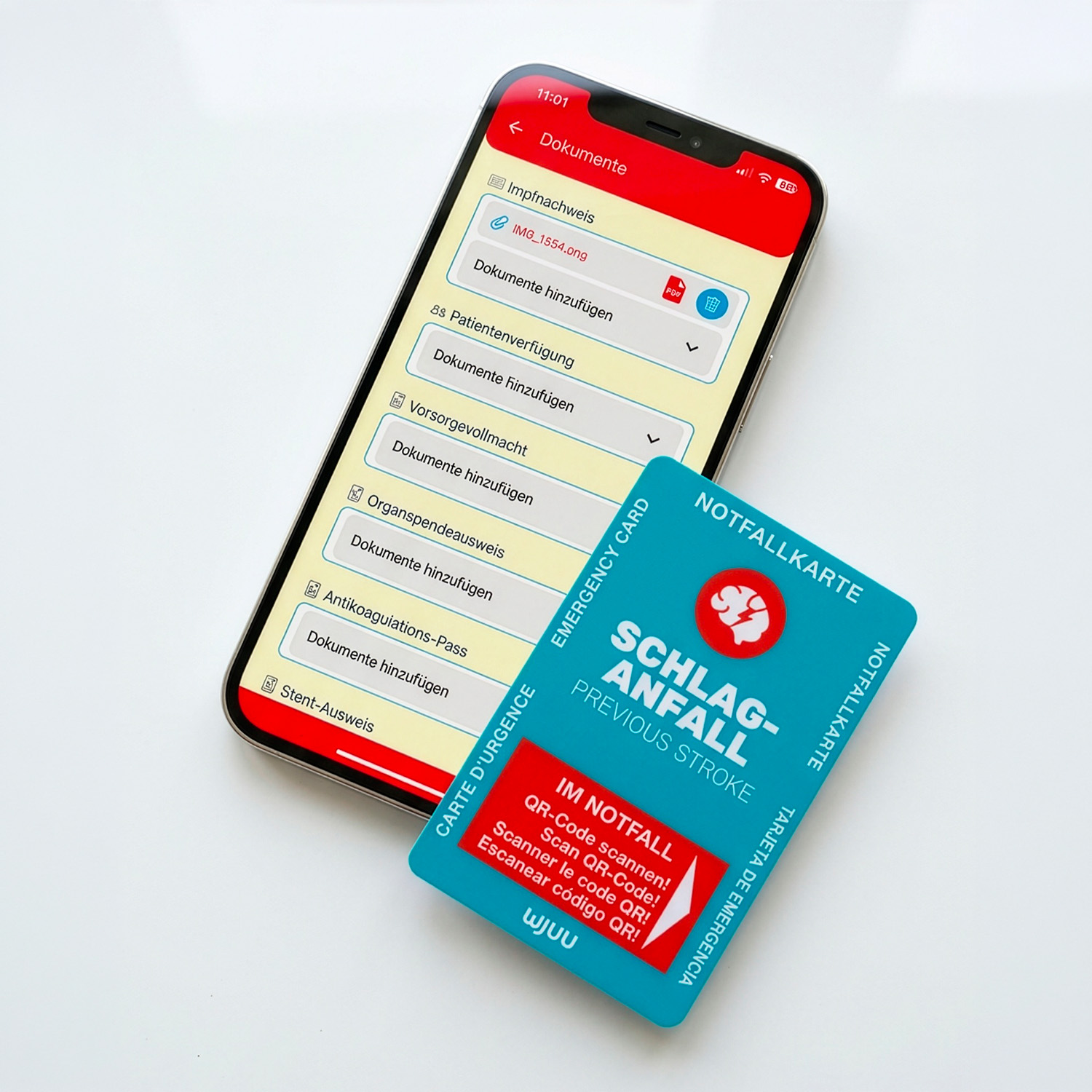 Wjuu Notfallkarte für Schlaganfallpatienten neben Smartphone mit digitalem Profil und Dokumenten